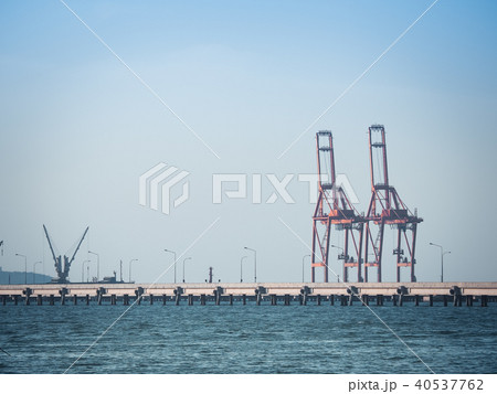 Port crane loads a container on Pier for transport Port crane loads a container on Pier for transport 40537762