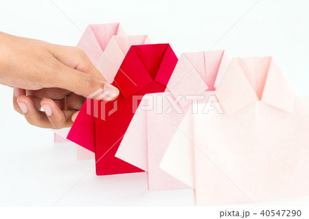 Hand selecting one Red among white origami shirt  40547290