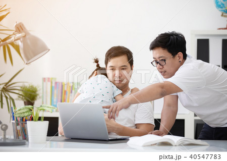 Asian family and little girl ,while dad works with notebook on w 40547783