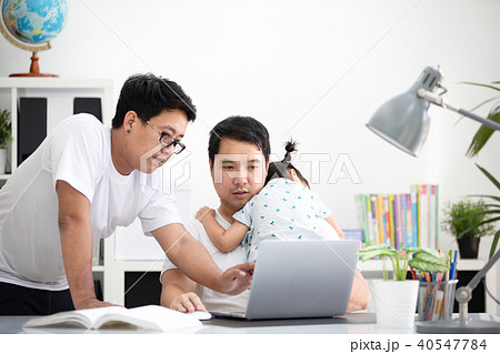 Asian family and little girl ,while dad works with notebook on w 40547784
