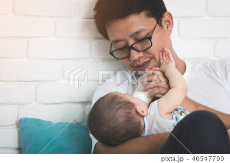 Nice moment. Agreeable young asian father holding his baby and s 40547790