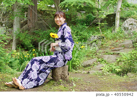 ひまわりを持ち微笑む浴衣姿の女性 40550942