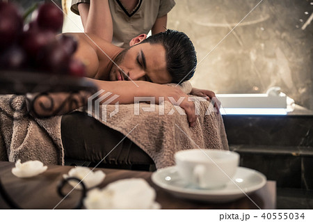 Young man lying down during traditional acupressure procedure Young man lying down during traditional acupressure procedure 40555034