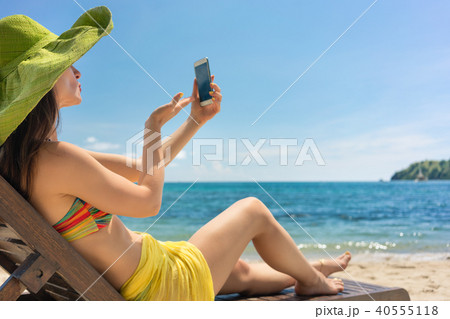 Young woman sending a love message through a selfie photo at the beach Young woman sending a love message through a selfie photo at the beach 40555118