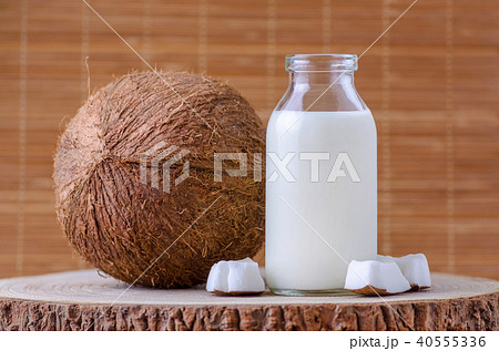 coconut milk in glass bottle on natural brown background coconut milk in glass bottle on natural brown background 40555336