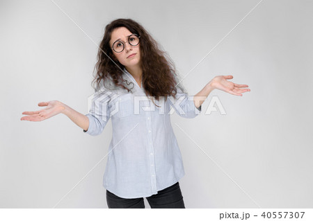 Young brunette girl with glasses. The girl spread her hands to the sides. 40557307