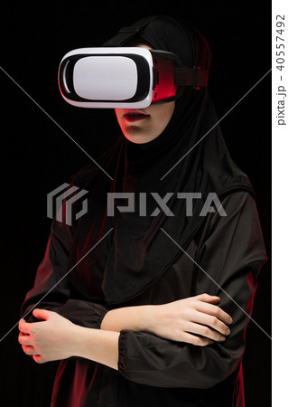 Portrait of beautiful smart young muslim woman wearing black hijab using virtual reality headset on Portrait of beautiful smart young muslim woman wearing black hijab using virtual reality headset on 40557492