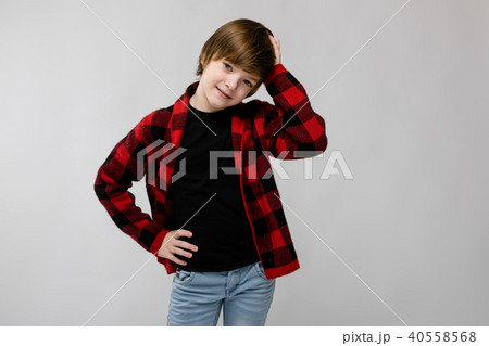Cute sweet smiling little caucasian boy in checkered shirt on grey background Cute sweet smiling little caucasian boy in checkered shirt on grey background 40558568