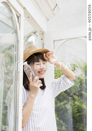 夏の暑い日にペットボトルを持って外に出る若い女性 40559056