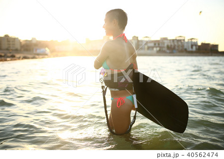 Sport girl in bikini on the beach with kiteboard 40562474