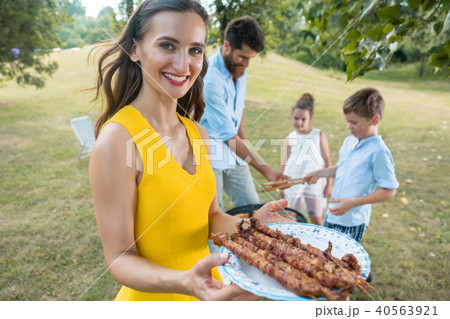 Portrait of mother holding plate with grilled steak skewers Portrait of mother holding plate with grilled steak skewers 40563921