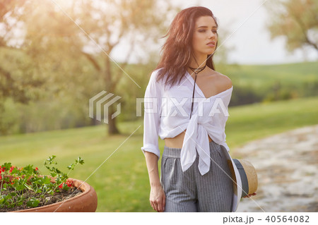Smiling summer woman with sunglasses in italian garden Smiling summer woman with sunglasses in italian garden 40564082