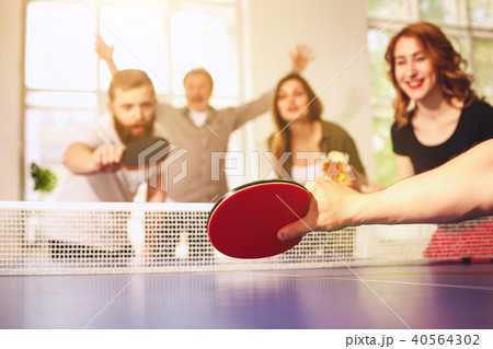 Group of happy young friends playing ping pong table tennis Group of happy young friends playing ping pong table tennis 40564302
