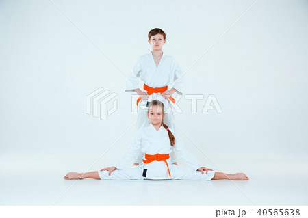 The boy and girl posing at Aikido training in martial arts school. Healthy lifestyle and sports The boy and girl posing at Aikido training in martial arts school. Healthy lifestyle and sports 40565638