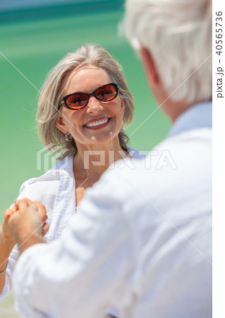 Happy Senior Couple Holding Hands on a Beach 40565736