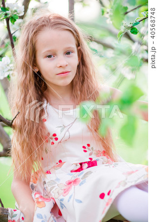 Adorable little girl in blooming apple tree garden on spring day 40568748