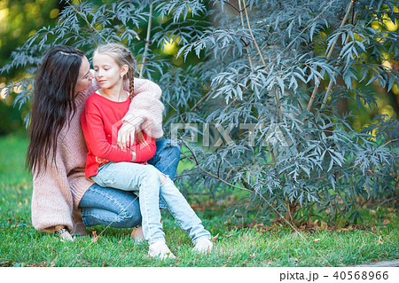 Adorable little girl with young mother in blooming garden on spring day Adorable little girl with young mother in blooming garden on spring day 40568966