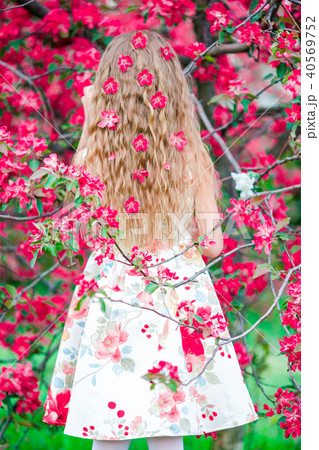 Adorable little girl in blooming apple tree garden on spring day 40569752