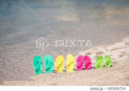 Family colorful flip flops on beach in front of the sea 40569754