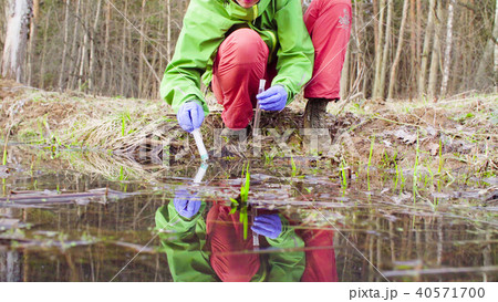 Scientist ecologist in the forest taking samples of water Scientist ecologist in the forest taking samples of water 40571700