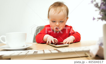 Happy child baby girl toddler sitting with keyboard of computer isolated on a white background Happy child baby girl toddler sitting with keyboard of computer isolated on a white background 40584017