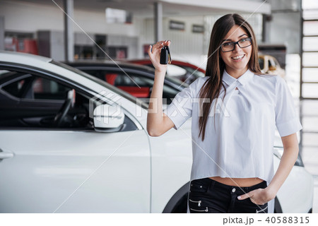 Young happy woman near the car with keys in hand Young happy woman near the car with keys in hand 40588315