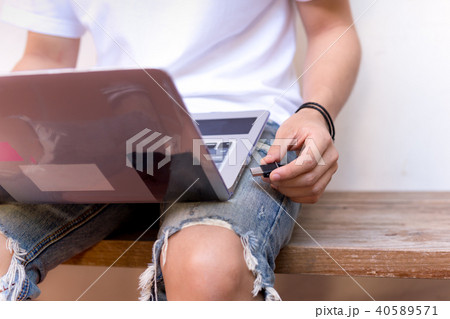 Young man copying data from notebook to usb drive 40589571