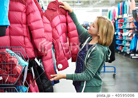 Woman chooses winter jacket in store 40595006