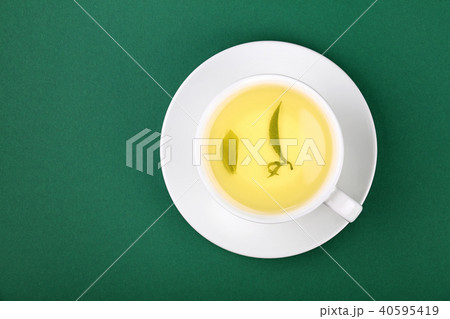 White cup of oolong tea on saucer on green 40595419