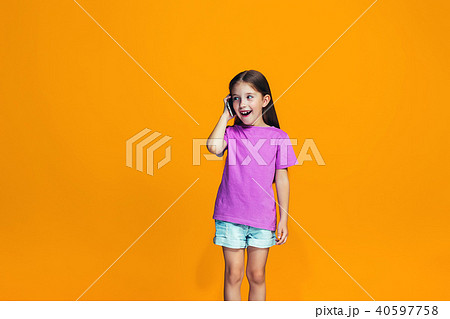 The happy teen girl standing and smiling with phone The happy teen girl standing and smiling with phone 40597758