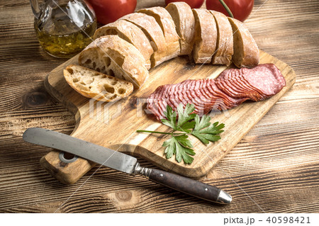 Italian ciabatta bread cut in slices with salami. 40598421