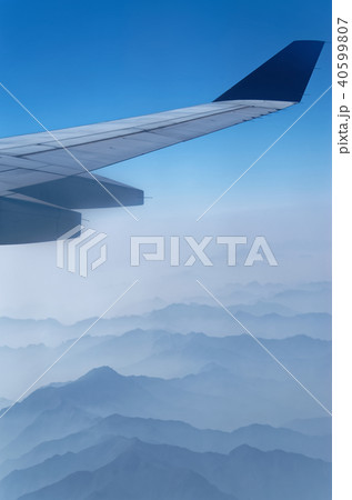 Airplane wing above mountains in a fog 40599807