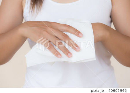 Woman cleaning her hands with a tissue. Woman cleaning her hands with a tissue. 40605946