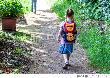 Little girls walking away with her filled backpack Little girls walking away with her filled backpack 40610685
