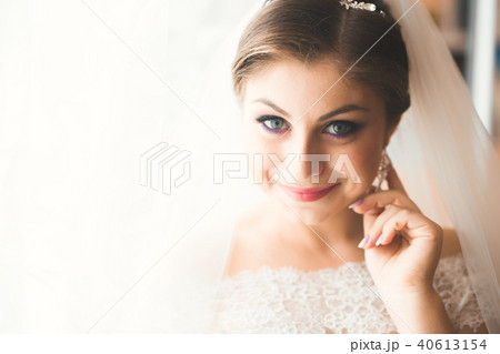 Luxury bride in white dress posing while preparing for the wedding ceremony 40613154
