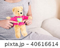 Pregnant woman hand holding teddy bear doll. 40616614