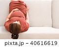 Young pregnant woman sitting on gray sofa top view 40616619