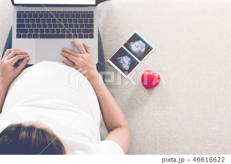 Pregnant woman is shopping online with laptop. 40616622