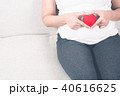 Happy pregnant woman holding love red heart shape. 40616625