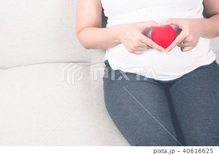 Happy pregnant woman holding love red heart shape. 40616625