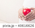 Happy pregnant woman holding love red heart shape. 40616626