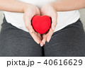 Happy pregnant woman holding love red heart shape. 40616629
