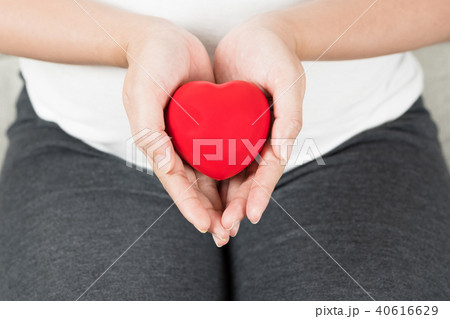 Happy pregnant woman holding love red heart shape. 40616629