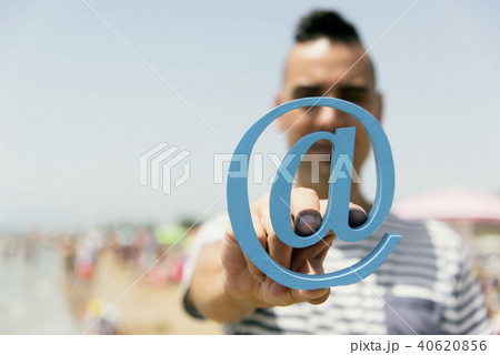 young man with an at sign on the beach 40620856