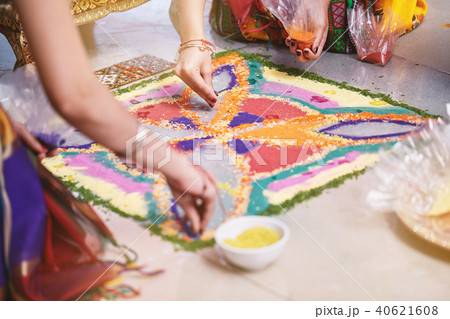 Bride's friend helps coloring rice art (Rangoli) 40621608