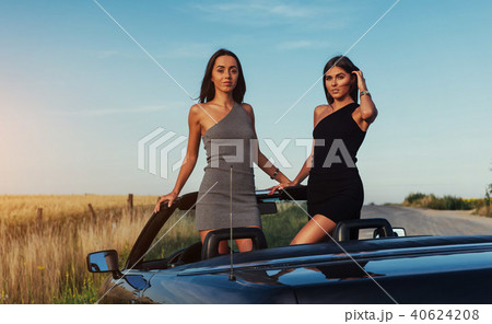 Beautiful two women sitting in a convertible 40624208