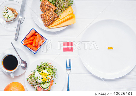 Concept of choice and equality - healthy food or medical pills, top view on the white wooden table 40626431