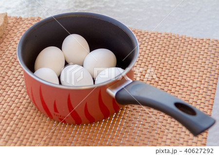 a few boiled eggs in a saucepan in the sun 40627292