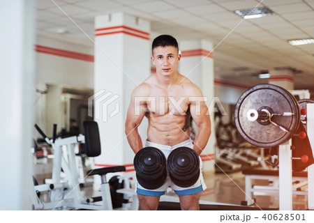 Portrait of a beautiful athletic guy muscles with weights Portrait of a beautiful athletic guy muscles with weights 40628501