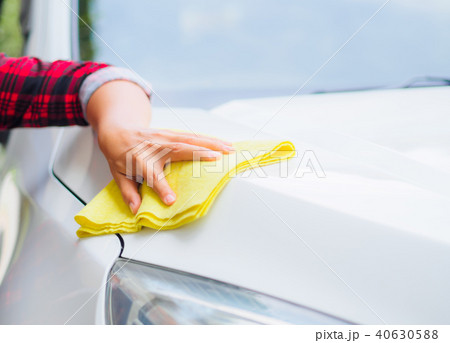 Hand with yellow microfiber cloth cleaning  car. 40630588